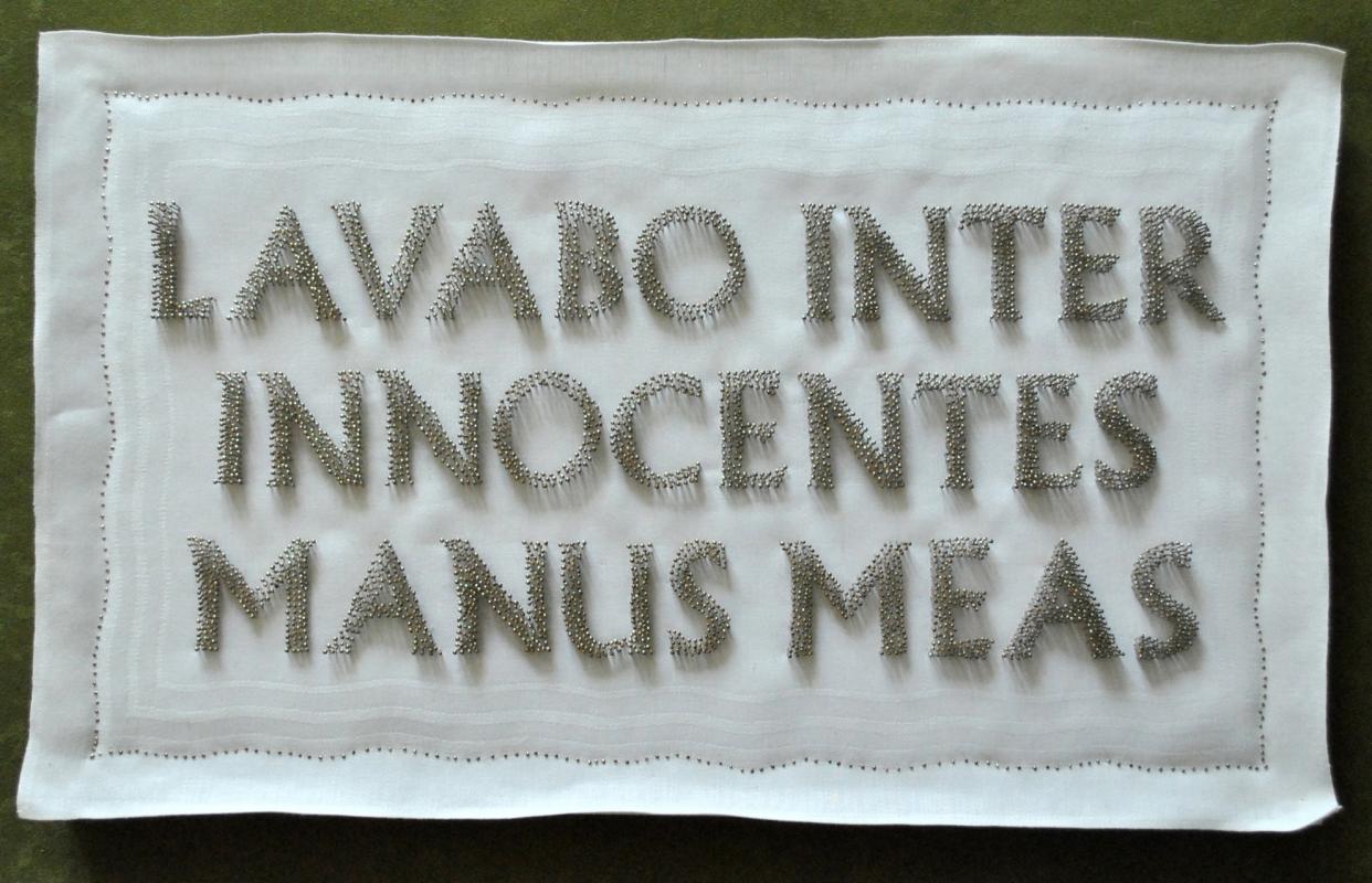 4.000 Stecknadeln stecken in einem Kelchtuch und fügen sich zu einem latainischen Gebet: Lavabo inter innocentes manus meas („In Unschuld will ich meine Hände waschen“)